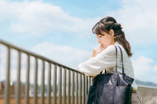 屋上で考え事をする女性