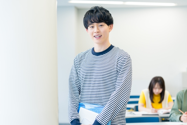 キャンパスを歩く男子大学生