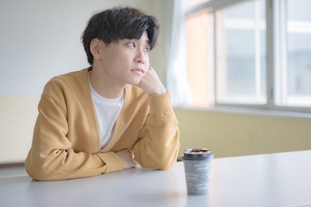 出会いがない大学生男子がカフェで今からやるべきことを考えているイメージ